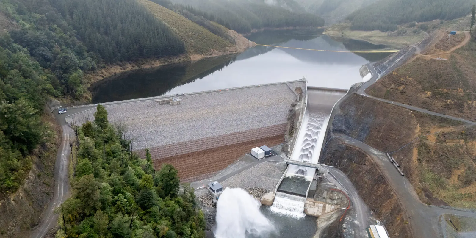 A panoramic view of Waimea Community Dam surrounded by forested hills